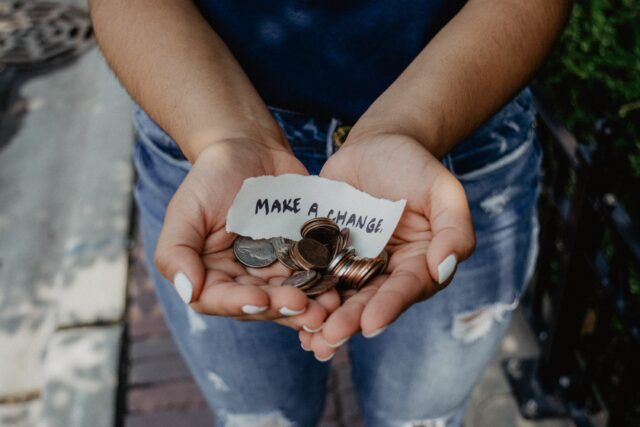 cash and 'make a change' note in someone's hand