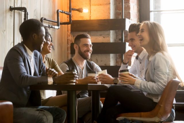 group of young people laughing over coffee