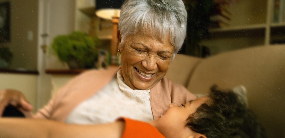 An older woman holding a child and smiling