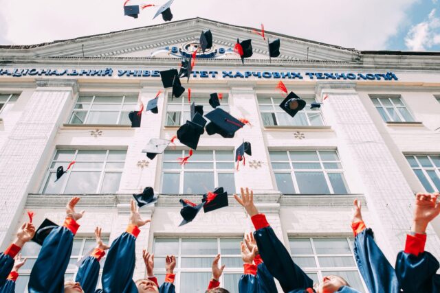 university graduates throwing hats in the air