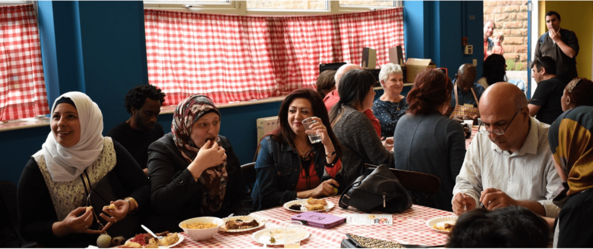 refugees sharing dinner at user centre